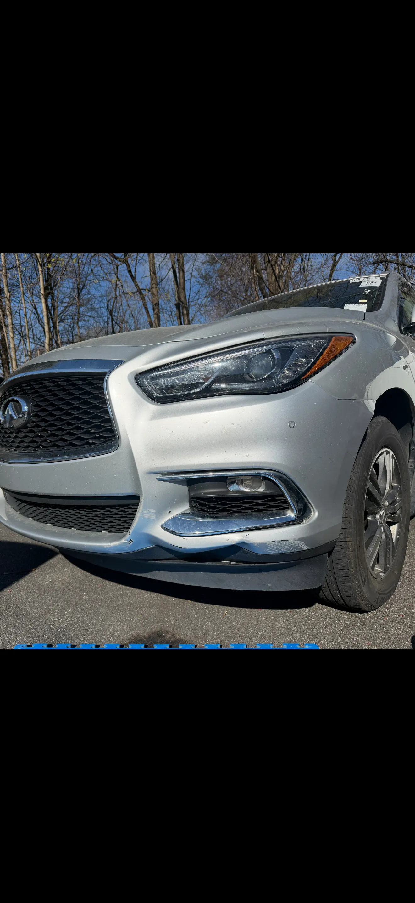 Silver Infiniti QX60 front bumper from a three-quarter angle, before repair.