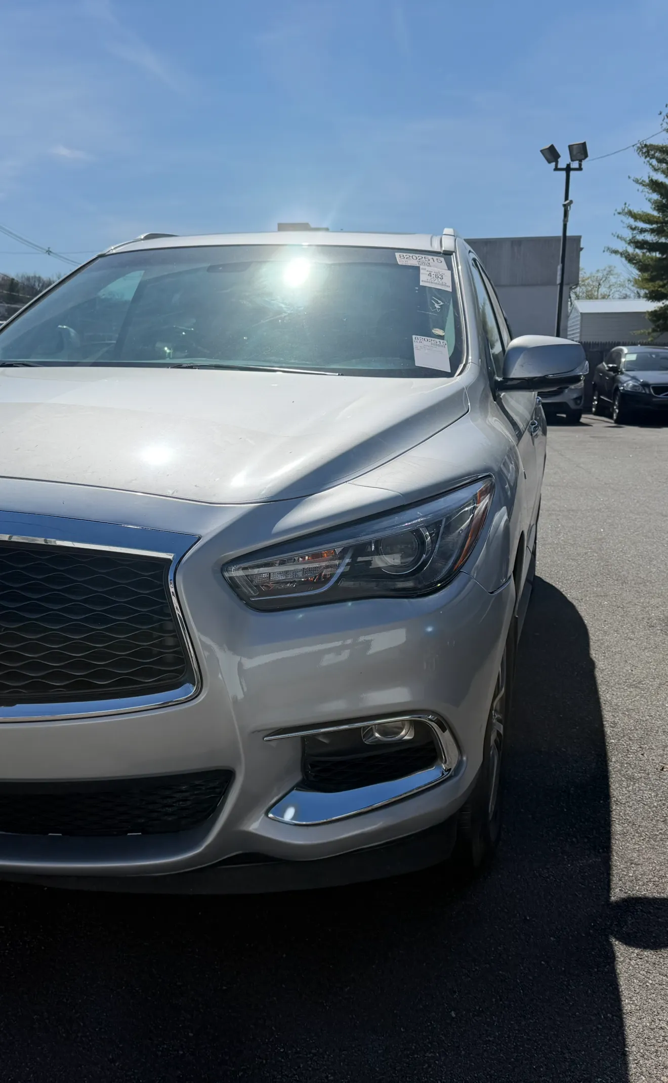 Silver Infiniti QX60 front bumper after repair, clean and smooth paint matched across grille, headlight, bumper, and wheel.
